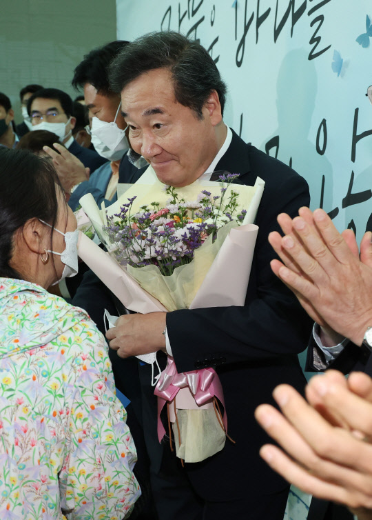 이낙연 전 더불어민주당 대표가 7일 인천국제공항 2터미널에서 미국으로 출국 전 취재진과 지지자들 앞에서 발언한 뒤 꽃다발을 받고 있다. 연합뉴스.